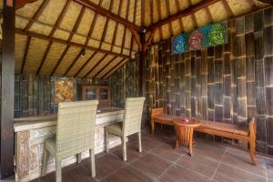 Habitación con 2 sillas y mesa de madera. en AlamGangga Villas Tirta Gangga, en Tirtagangga