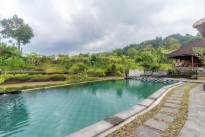 uma piscina de água em frente a uma casa em AlamGangga Villas Tirta Gangga em Tirtagangga