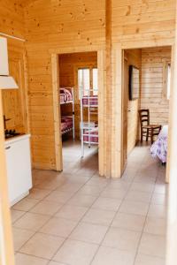 a living room of a wooden cabin with a kitchen at Camping La Pineta in Porto Recanati