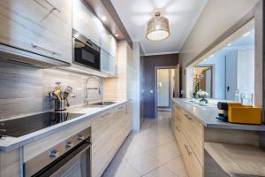 a large kitchen with wooden cabinets and a sink at Convista Flat T2+1 in Portimão