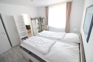 Duas camas num quarto com uma janela em Haus-Hachtmann em Cuxhaven
