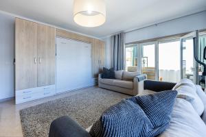 a living room with a couch and a chair at Convista Flat T2+1 in Portimão