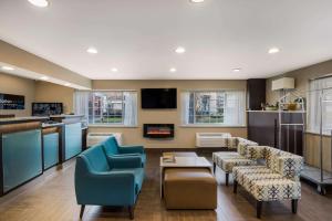 a living room with two blue chairs and a kitchen at Clarion Pointe Downtown in Syracuse