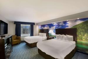 una camera d'albergo con due letti e una tv di Clarion Pointe Downtown a Syracuse