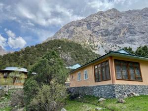 una casa di fronte a una montagna di Mountain Base ARTUCH a Panjakent