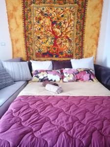 a bed in a room with a tapestry at Demetra Piccola Casa Vacanze in Ielsi