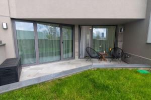 a patio with two chairs and a table and some grass at Georgi's 1 Bedroom Quiet Apartment with Garage in Sofia