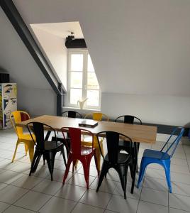 une salle à manger avec une table et des chaises colorées dans l'établissement L’INSOLITE, à Pierry