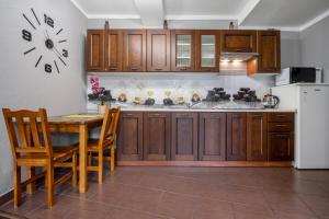 a kitchen with a table and a clock on the wall at RentPlanet - Apartamenty Krzeptówki in Zakopane