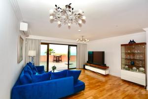 a living room with a blue couch and a television at BLUE DIAMOND luxury apartment with amazing seaview in Costa Adeje in Adeje