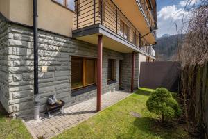 a house with a balcony on the side of it at RentPlanet - Apartamenty Krzeptówki in Zakopane