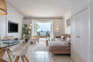 sala de estar con sofá y mesa en Sea Front Beach house Micaela G, en Marbella