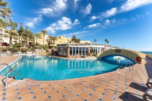 una gran piscina en un complejo con palmeras en Sea Front Beach house Micaela G, en Marbella