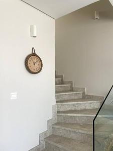 a clock on the wall next to some stairs at Turquaze Guesthouse in Muscat