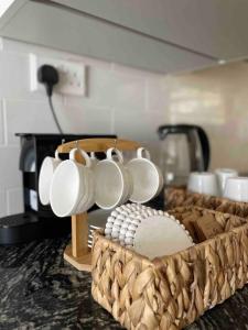 a basket of coffee cups and a baseball on a counter at Turquaze Guesthouse in Muscat
