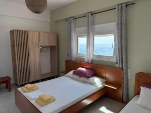 una camera da letto con un letto e due asciugamani di Voula Beach a Lentas