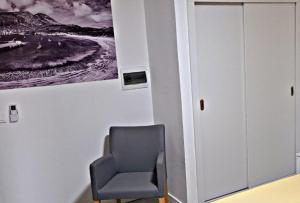 einen Stuhl in einem Raum mit einem Bild an der Wand in der Unterkunft Apartamentos Santiago - Tarrafal in Tarrafal