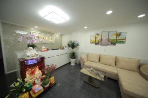胡志明市的住宿－PHÚ GIA BÙI VIỆN HOTEl，客厅配有沙发和桌子