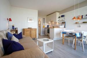 een woonkamer en een keuken met een bank en een tafel bij Bellevue-Haus-A-Wohnung-9 in Großenbrode