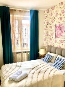 een slaapkamer met een groot bed en blauwe gordijnen bij Apartament Starogdański 4 in Gdańsk