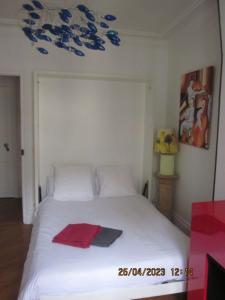 a bedroom with a white bed with a red towel on it at Bed and Breakfast Paris Centre in Paris