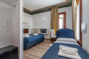 Habitación con 2 camas y sofá azul en Hotel ai do Mori, en Venecia