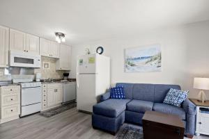 a living room with a blue couch and a white refrigerator at Myrtle Beach Resort A402 in Myrtle Beach