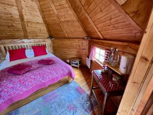 ein Schlafzimmer mit einem Bett in einer Holzhütte in der Unterkunft The Nest Glamping Pod in Dalmally