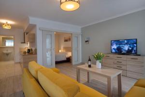 ein Wohnzimmer mit einem gelben Sofa und einem Tisch in der Unterkunft Apartamenty Feniks in Świnoujście