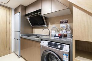 a kitchen with a washer and dryer in a room at Cloud Land Apartment 翡翠华庭 in Guangzhou