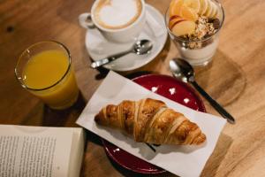 - une table avec un plateau de croissants et une tasse de café dans l'établissement Central Hostel Bordeaux Centre, à Bordeaux