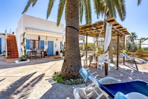 a resort with a palm tree and chairs at Cas Padri in Santanyi