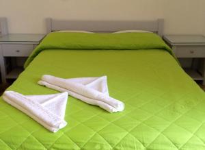 a green bed with two white towels on it at Pension Askas in Aegiali