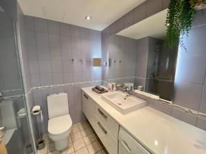 W łazience znajduje się umywalka, toaleta i lustro. w obiekcie City Heart Apartment with a Sunny Rooftop Terrace w Tallinnie