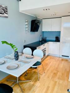 Biały stół jadalny z krzesłami i kuchnia w obiekcie City Heart Apartment with a Sunny Rooftop Terrace w Tallinnie