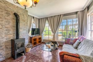 salon z kanapą i piecem opalanym drewnem w obiekcie Cypress House w mieście La Zubia