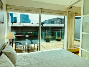 sypialnia z łóżkiem i dużym szklanym oknem w obiekcie City Heart Apartment with a Sunny Rooftop Terrace w Tallinnie