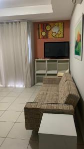 a living room with a couch and a flat screen tv at Flat Village - Aldeia das Águas in Barra do Piraí