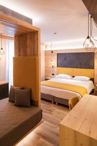 a hotel room with two beds and a table at Hotel Piccola Baita in Molveno