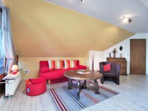 sala de estar con sofá rojo y mesa en Ferienwohnung Thiessen, en Silberstedt