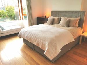 Un dormitorio con una cama grande y una ventana en The Moorings- near the sea en Tramore