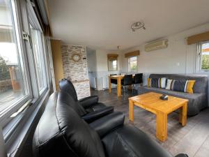 a living room with a couch and a table at Chalet Zeeweg in Nunspeet