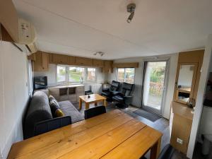 a living room with a couch and a table at Chalet Zeeweg in Nunspeet