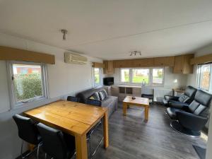 a living room with a couch and a table at Chalet Zeeweg in Nunspeet