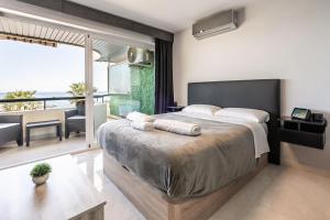 - une chambre avec un grand lit et un balcon dans l'établissement Beachfront Studio with Stunning Sea Views, à Marbella