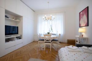 a white living room with a table and a chandelier at Vedrana-Free garage in Zagreb