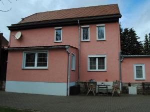 een roze huis met een tafel ervoor bij Ferienhaus Lindenhof 
