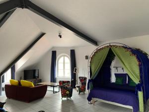 a bedroom with a bed and a couch in a room at L’INSOLITE in Pierry