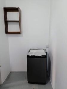 a black trash can in a white room with a mirror at M Tower Appartment in Post of Flacq
