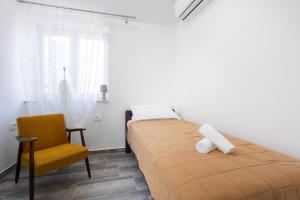 um quarto com uma cama, uma cadeira e uma janela em Residence Marina em Split
